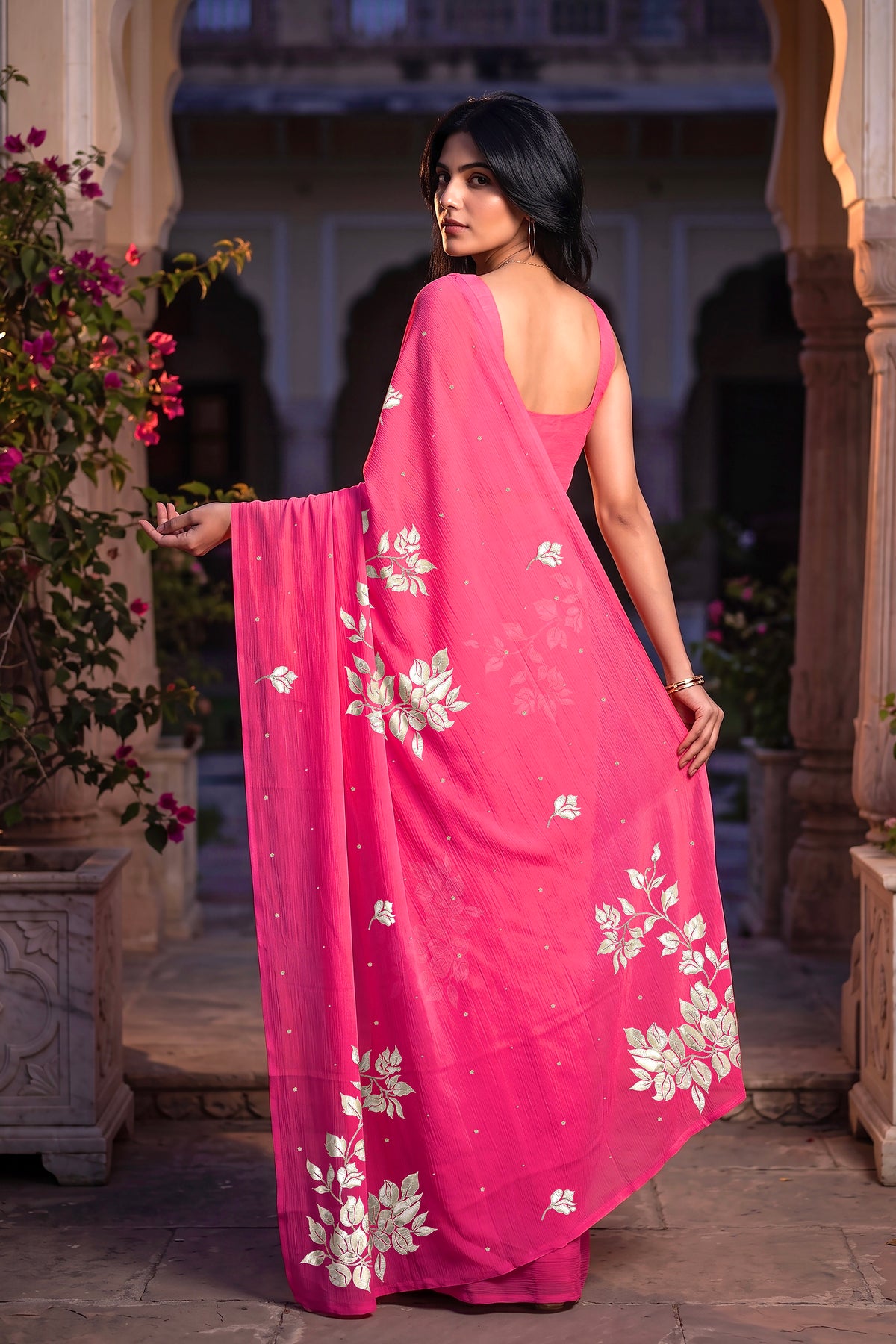Indian Model wearing Umaid Couture Fuchsia Rani Bougain Saree standing in a courtyard 