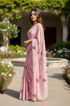 An Indian Model wearing a pink Grape vine saree by Umaid Couture, standing in a garden courtyard