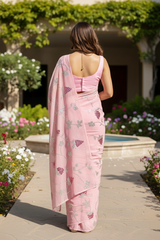 An Indian Model wearing a pink Grape vine saree by Umaid Couture, standing in a garden courtyard