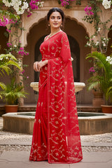 A model wearing a vibrant red gulmohar glow saree by umaid couture, standing in a garden courtyard