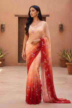 Woman wearing a traditional saree with a gradient design in front of a beige wall. Product by Umaid Couture.
