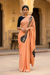 A woman in peach saree embellished with Sitar motif by Umaid Couture