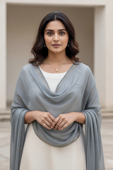 Woman wearing a light blue scarf over a white outfit with a neutral background. product by Umaid Couture