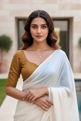 Woman wearing a white saree with a gold blouse outdoors. product by Umaid Couture