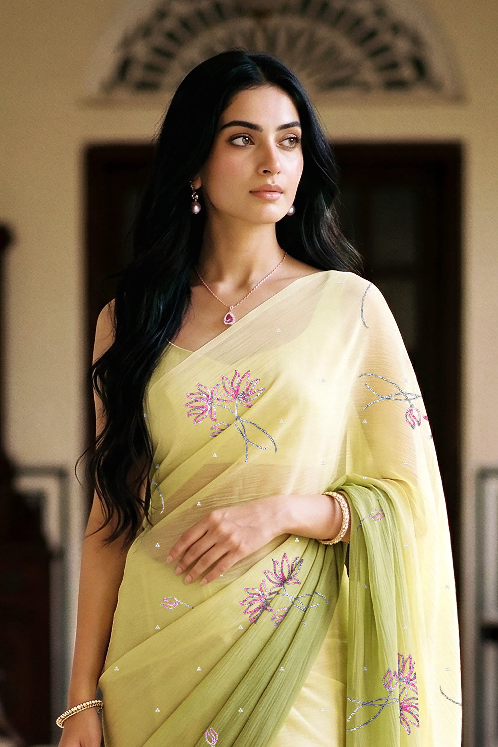 woman in green gradient saree with beautiful lotus motif made with pink and silver sequins and finely done with aari-zardosi made by umaid couture.