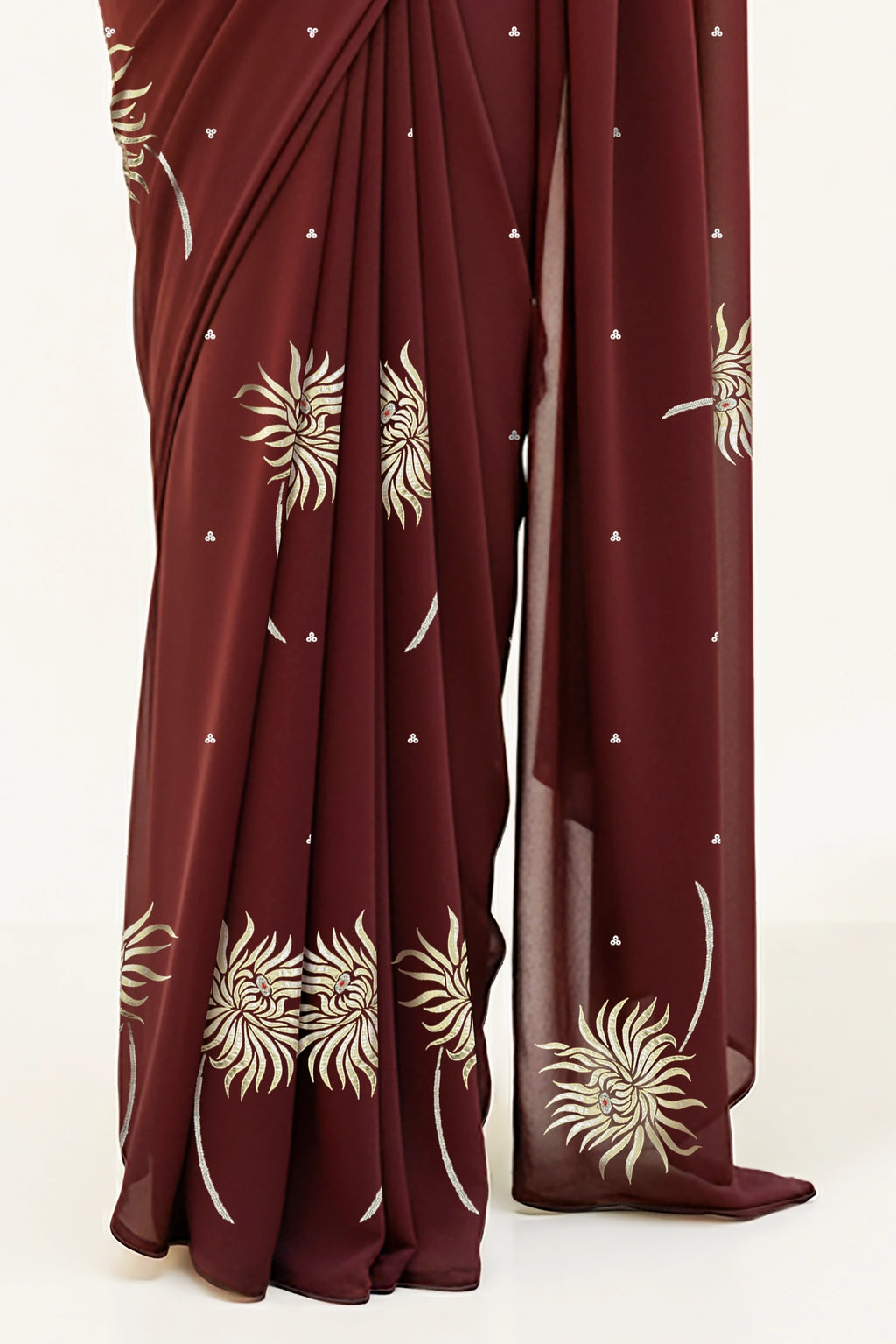 An Indian Woman in dark chocolate color saree embellished with Shevanti flower Motifs made of Gota, Zari and Sequins by Umaid Couture