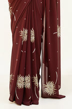 An Indian Woman in dark chocolate color saree embellished with Shevanti flower Motifs made of Gota, Zari and Sequins by Umaid Couture