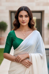Woman wearing a green blouse and white saree outdoors. product by Umaid Couture