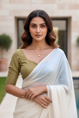 Woman wearing a traditional outfit with a white saree and green blouse in an outdoor setting. product by Umaid Couture