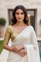 Woman wearing a white saree with a gold blouse in an outdoor setting. product by Umaid Couture