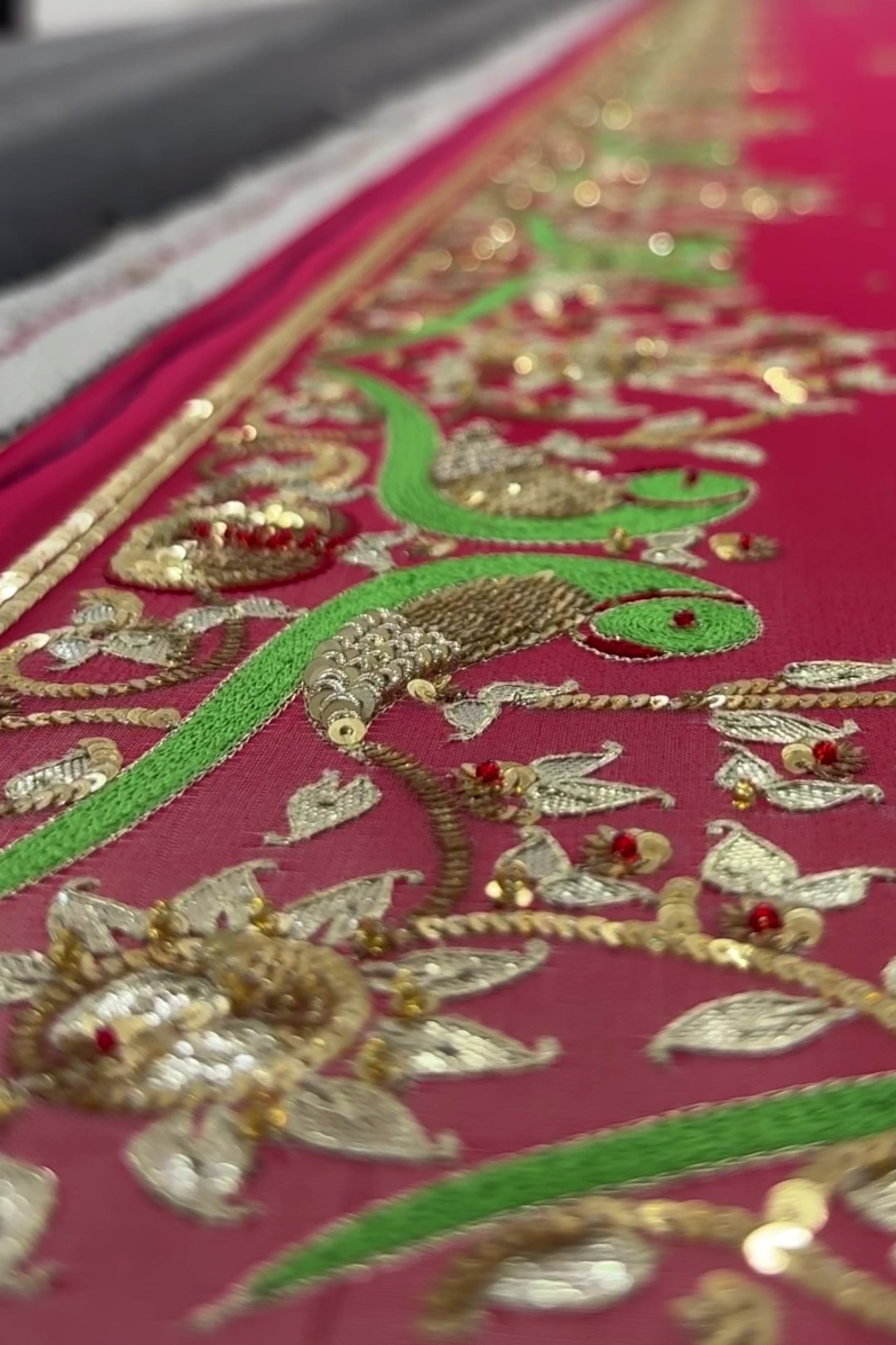 Video of Artisan making pretty parrot Aari-Zardosi handwork fuchsia saree by Umaid Couture