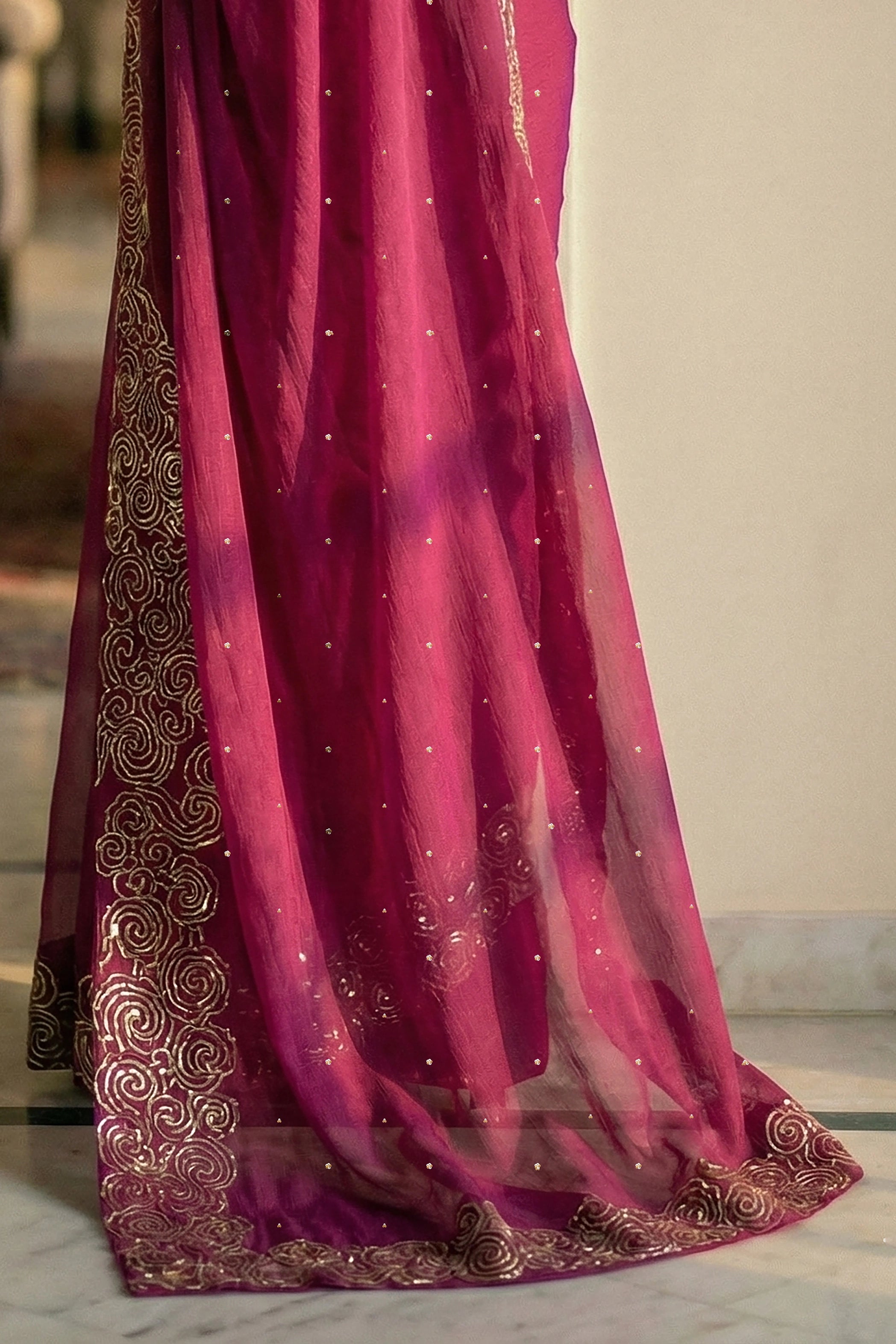 Woman in mulberry red saree with artistic cloud vines border on saree made by umaid couture.